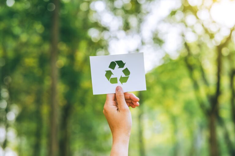 Una mano con el símbolo de reciclaje representando la sostenibilidad